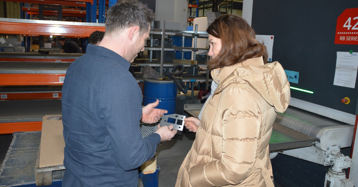 Dominik Listl zeigt Landrätin Tanja Schweiger Werkstücke von QABUS